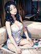A woman in a white dress sitting in a bathtub.