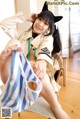 A woman in a cat costume sitting on a chair.