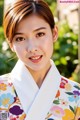 A woman in a colorful kimono posing for a picture.