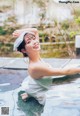 A woman in a white dress sitting in a pool of water.