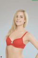 A woman in a red bra posing for a picture.